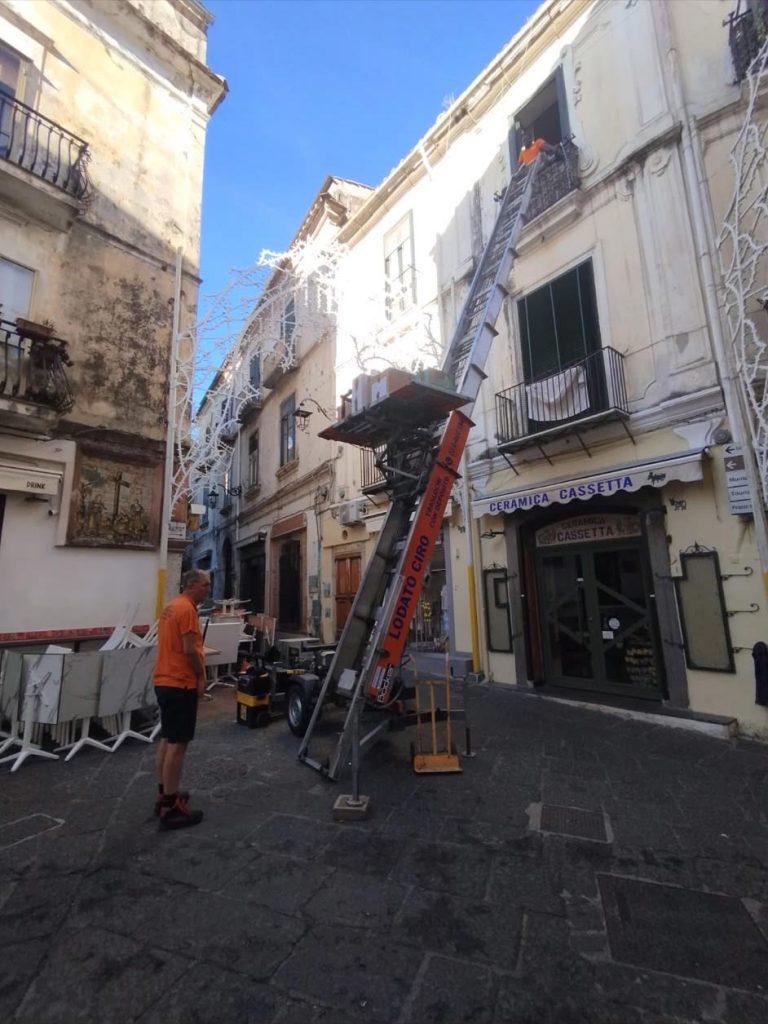Autoscala Ciro Lodato Traslochi appoggiata a una finestra in una strada stretta del centro storico